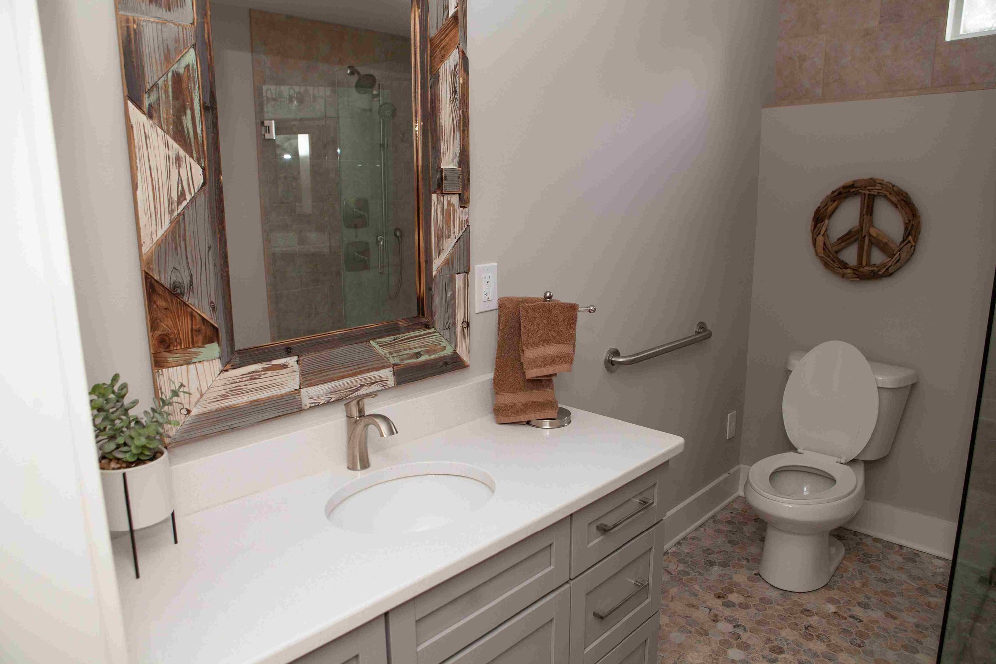 Boho Designed Bathroom with Geometric Flooring and Wood Accent Mirror _ PAXISgroup Custom Home Builders in GA_11zon