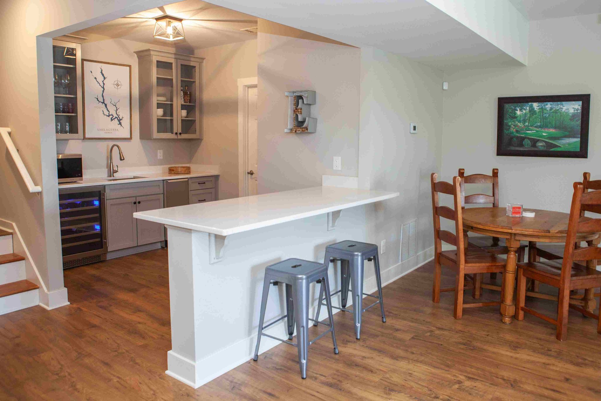 Downstairs Bar with Bar Seating and Wine or Beverage Cooler _ PAXISgroup Custom Home Builders in GA_11zon