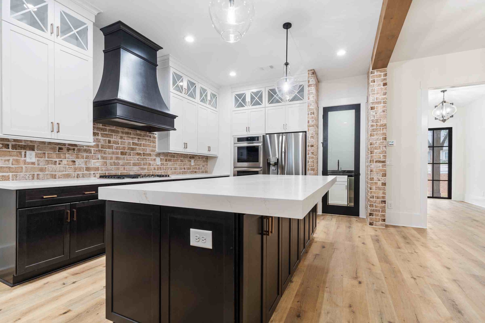 Black Kitchen with large white island countertop | PAXISgroup