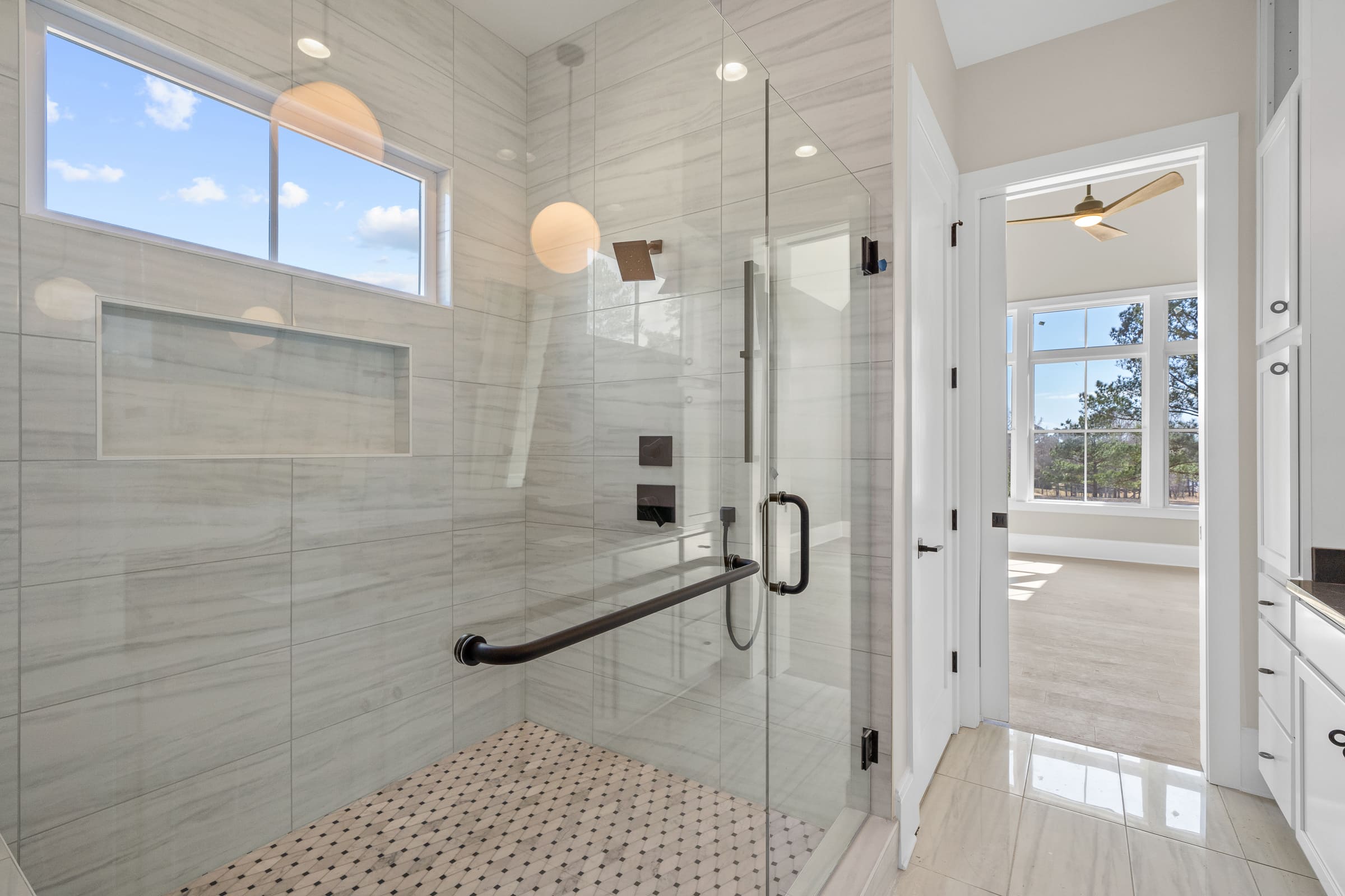Primary Bathroom Shower with Large Glass Doors and Gorgeous Tiling Features |PAXISgroup Primary Bathroom Shower with Large Glass Doors and Gorgeous Tiling Features |PAXISgroup
