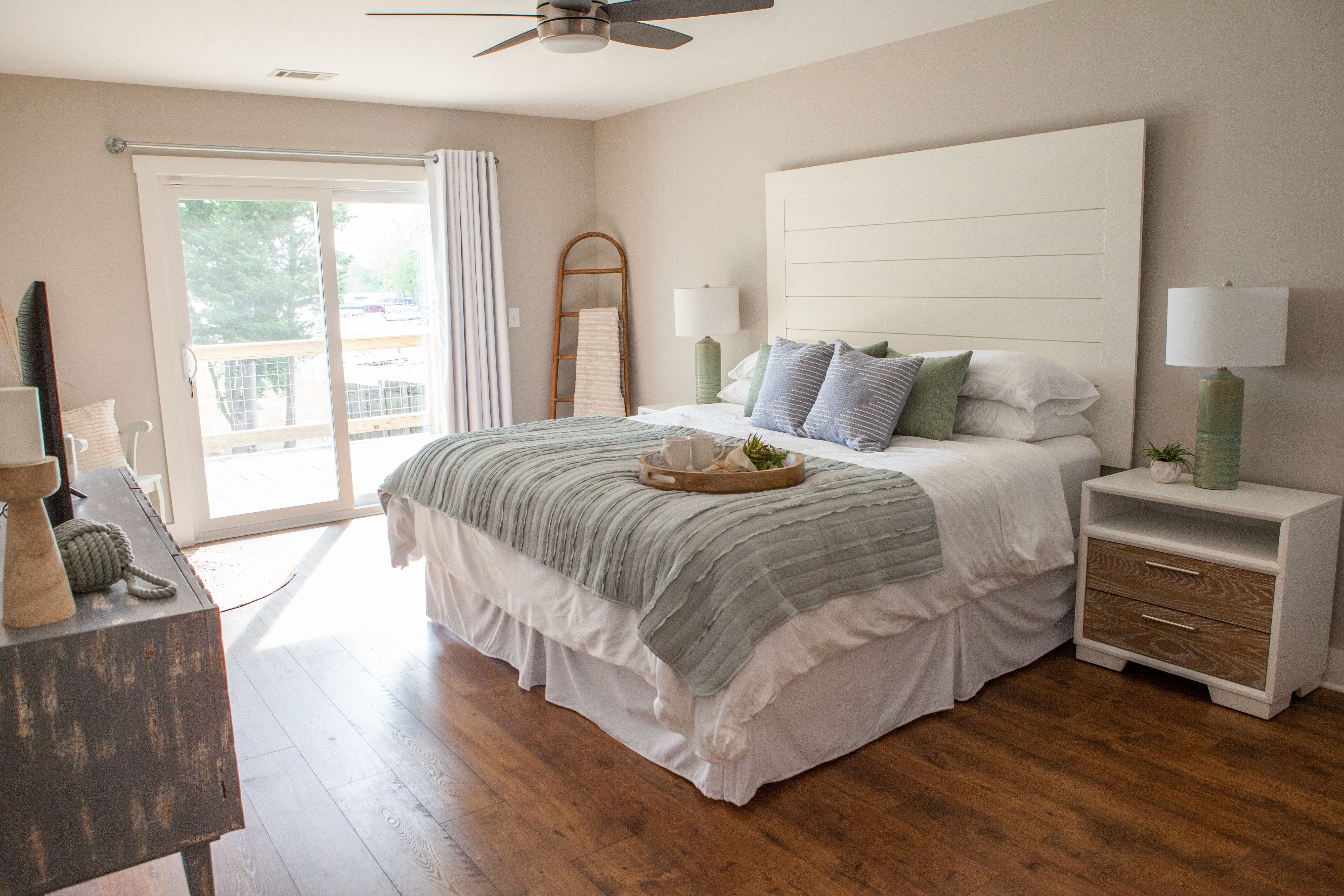 Primary Bedroom with Sliding Glass Door and Shiplap Headboard | PAXISgroup Custom Home Builders in GA