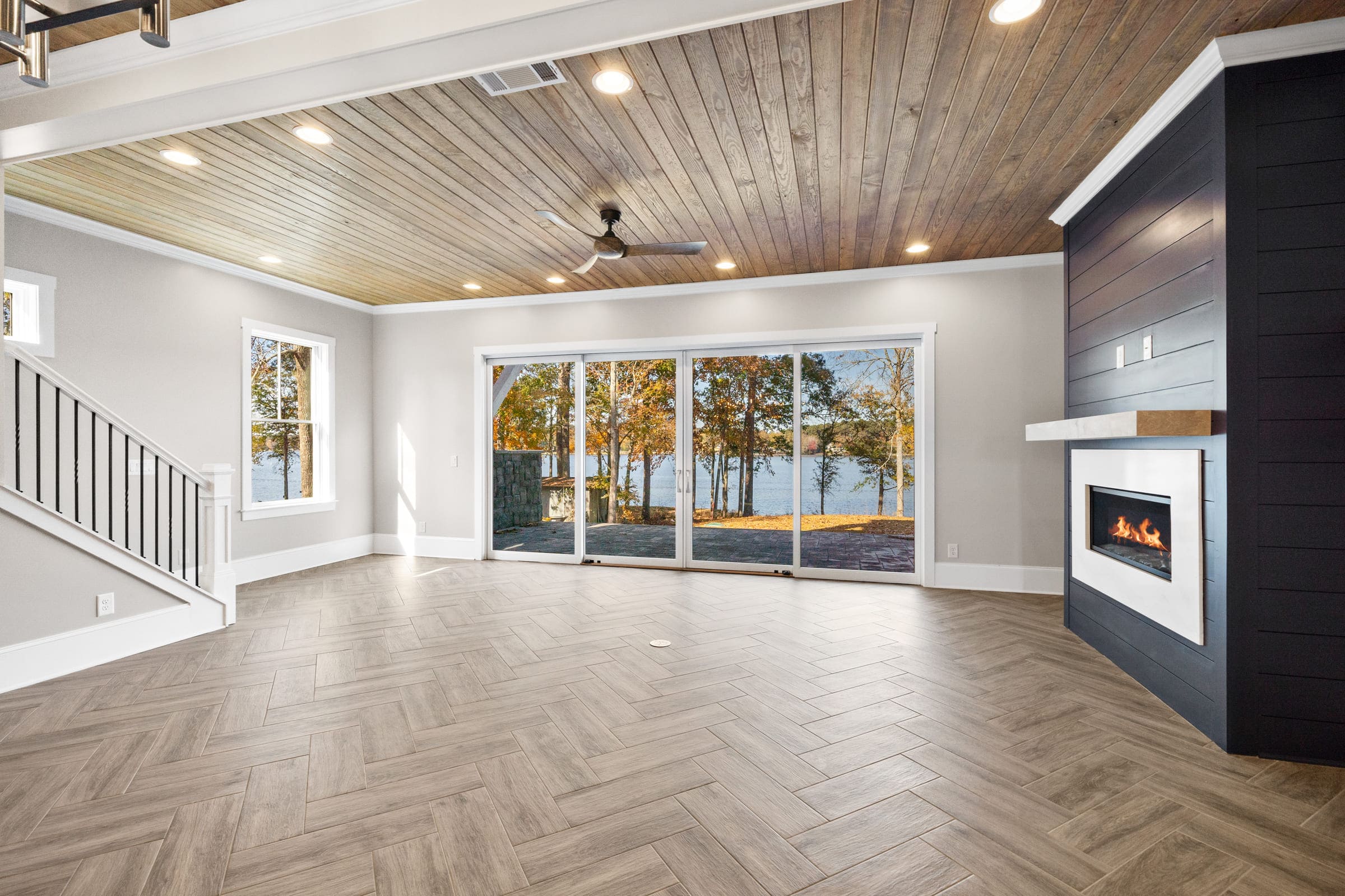 Detailed Wood Floor with Full Glass Patio Door Leading to Backyard and Lakefront 