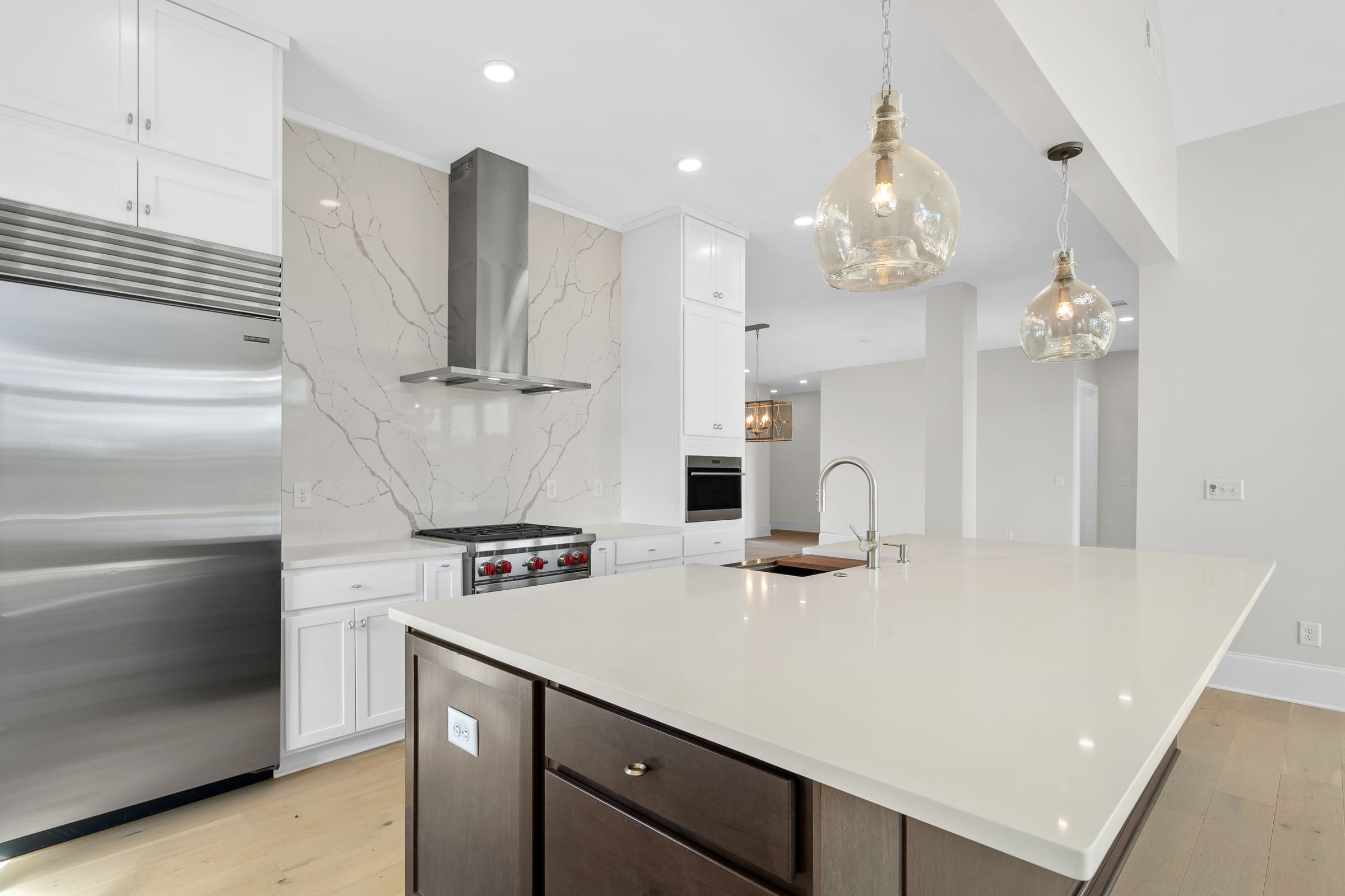 Large Open Kitchen with White Accents and Stainless Steel Appliances |PAXISgroup