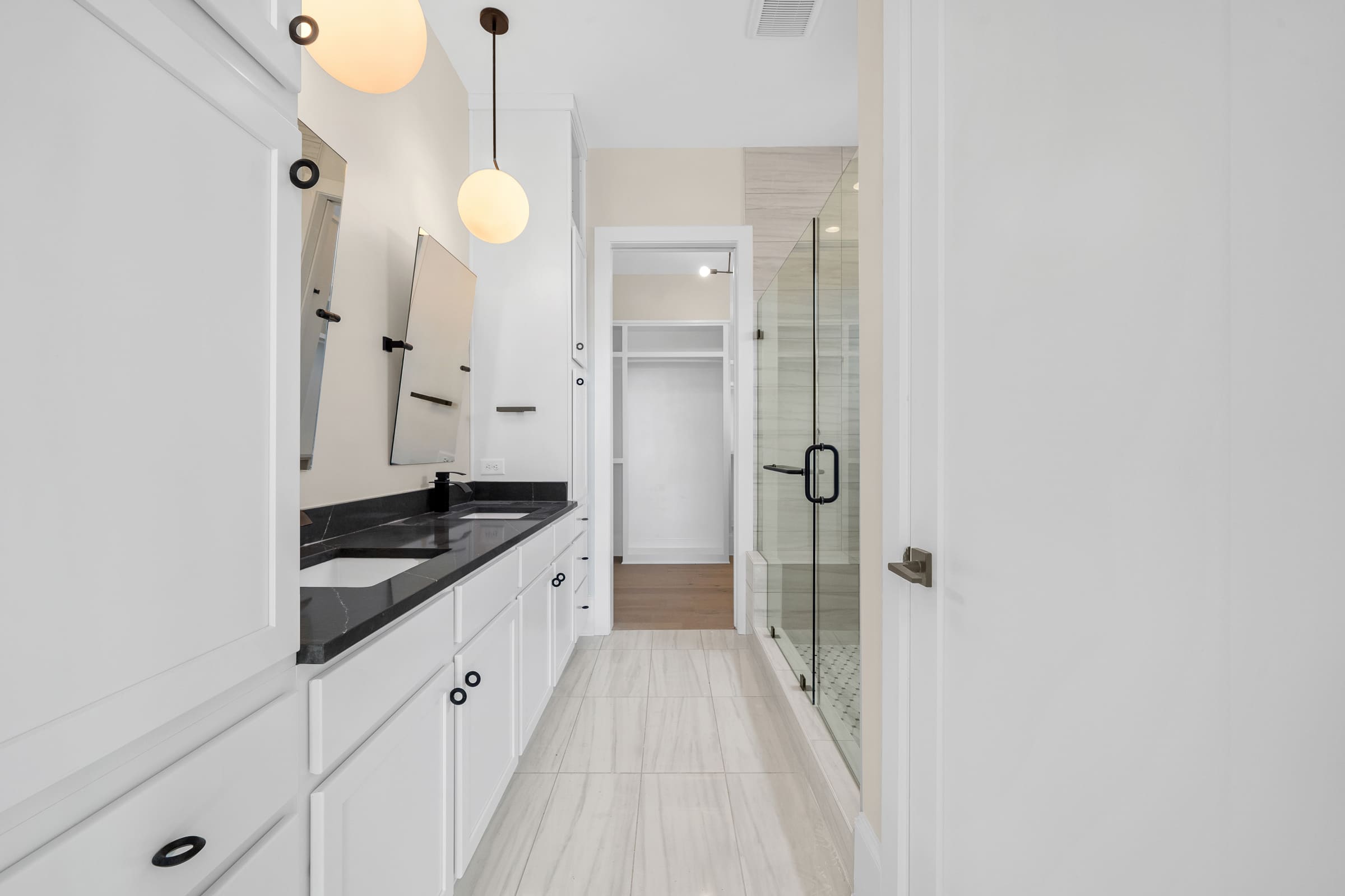 Primary Bathroom with White Cabinetry and Dark Stone Counter Tops with Unique Square Mirrors |PAXISgroup