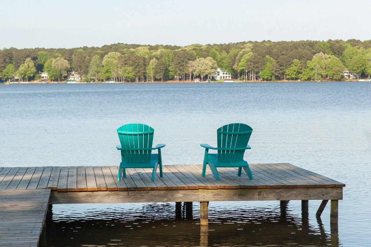Adirondack Chair Seating on Dock Overlooking Lake Oconee at Beautiful Remodeled Lakefront Home | PAXISgroup Custom Home Builders in GA