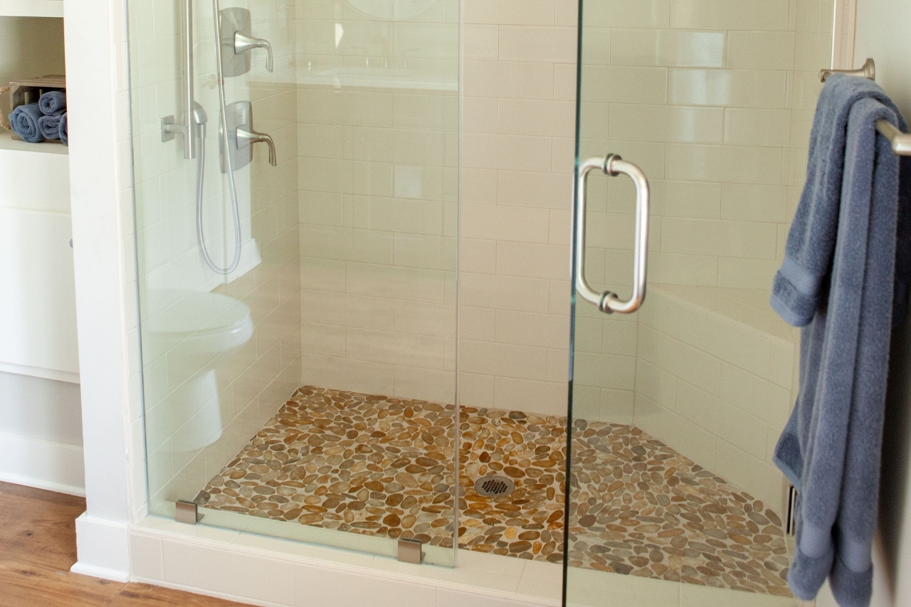 Primary Bathroom Walk-In Glass Door Shower and Geometric Tile Flooring | PAXISgroup Custom Home Builders in GA