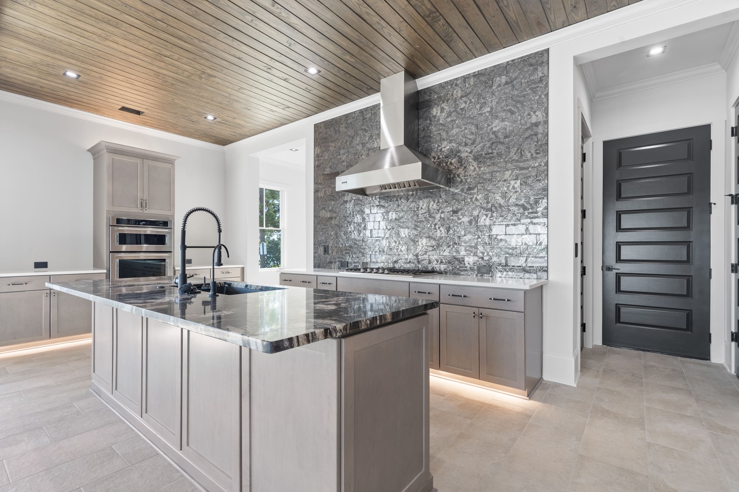 Full Stone Kitchen with Light brown Cabinets and Dark Countertops|PAXISgroup