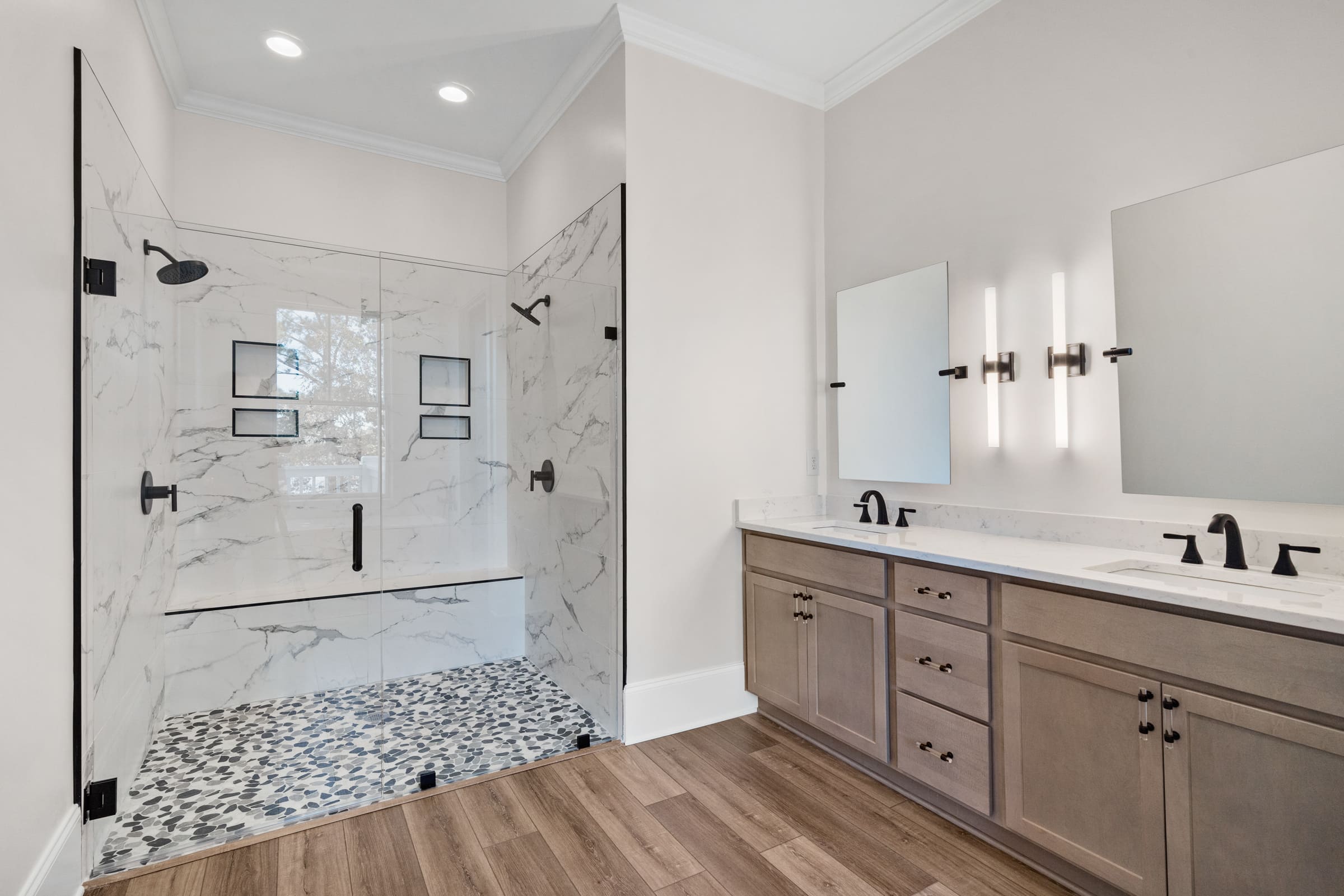 Large Walk-In Shower with White Marble Walls. There is Also a Large Two Sinked Vanity with Square Mirrors 