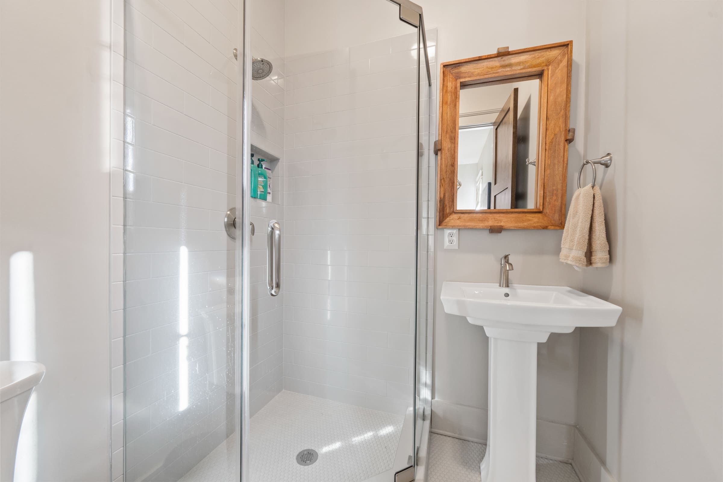 Small White-tiled Shower and Single Sink Bathroom | PAXISgroup