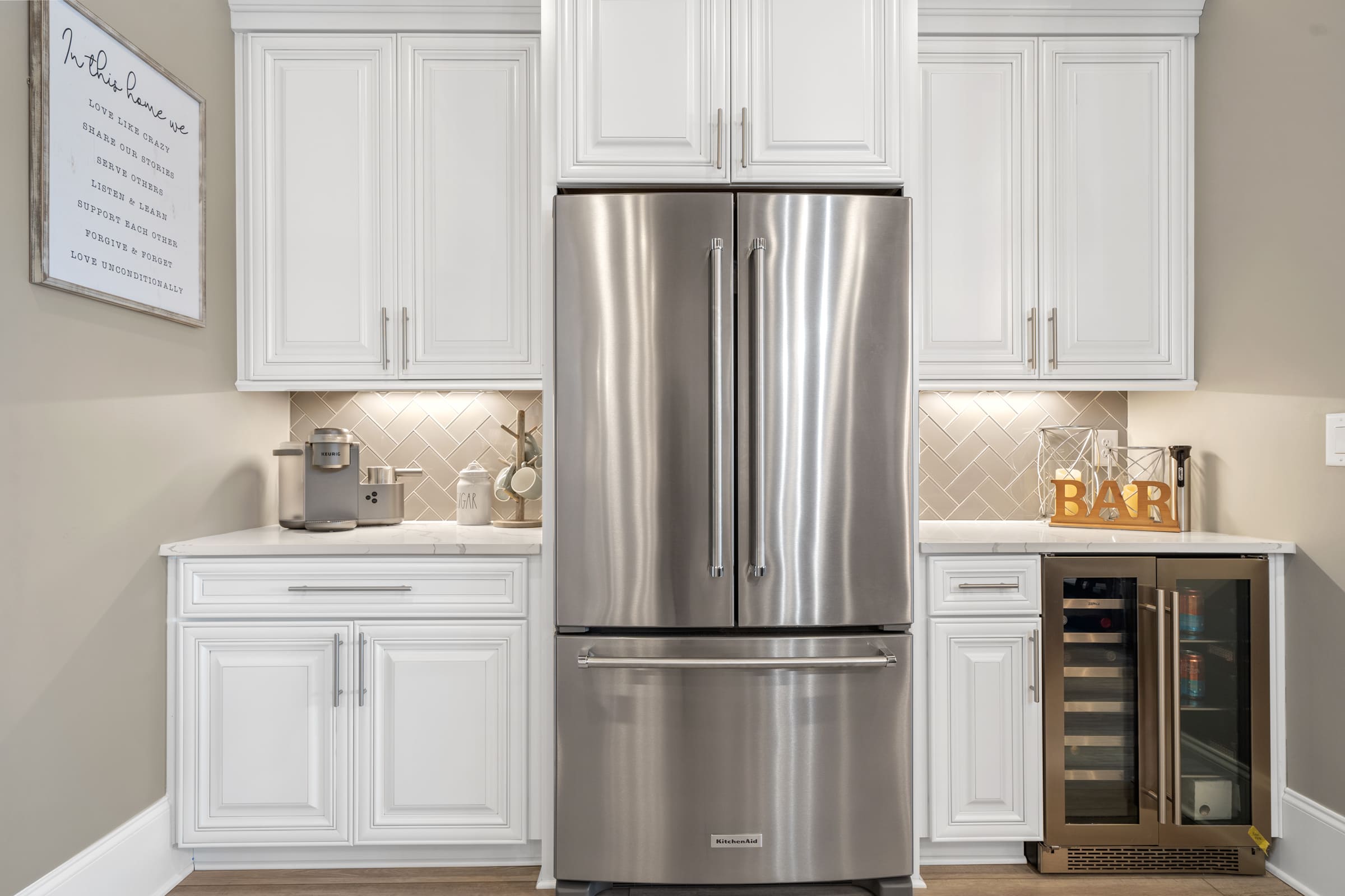 White Cabinetry Surrounding the Refrigerator and Built-in Bar Area |PAXISgroup