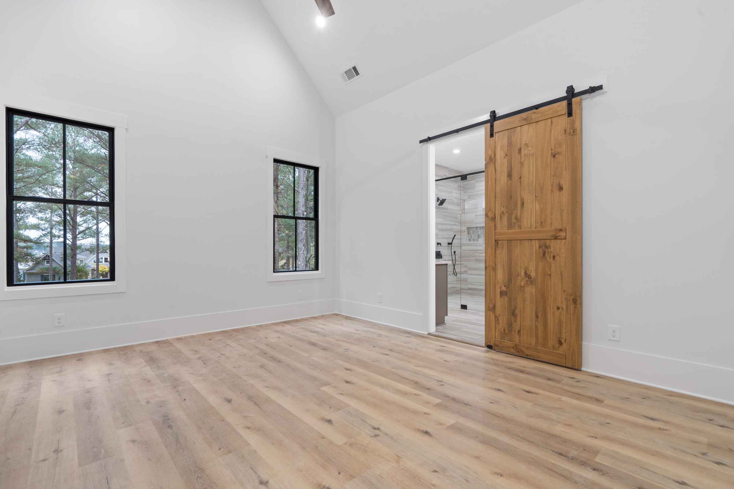 Paxis Indian Trail bedroom with farmhouse barn door into bathroom | Paxisgroup